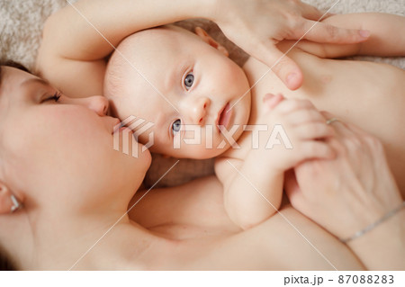 a naked mother and the baby on the bed. maternal and child health.  87088283