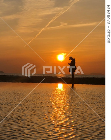 父母ヶ浜の夕日と男性 87088484