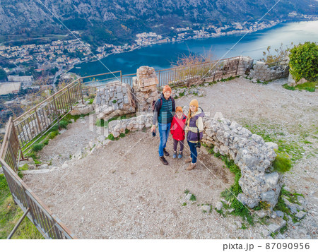 Family of hikers on Hiking in Kotor Old Town Ladder of Kotor Fortress Hiking Trail. Aerial drone view 87090956
