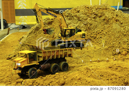 SELANGOR, MALAYSIA - MARCH 16, 2021: Selected focused on remote control construction machinery toys. Placed inside the game set seems to be on an actual construction site. SELANGOR, MALAYSIA - MARCH 16, 2021: Selected focused on remote control construction machinery toys. Placed inside the game set seems to be on an actual construction site. 87091280