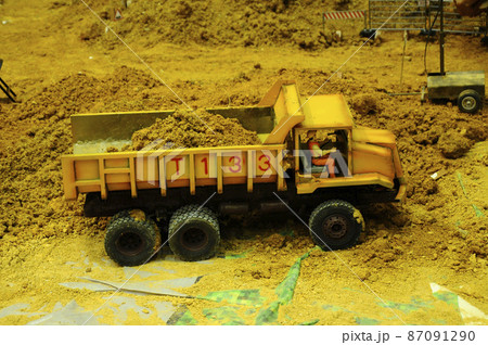 SELANGOR, MALAYSIA - MARCH 16, 2021: Selected focused on remote control construction machinery toys. Placed inside the game set seems to be on an actual construction site. 87091290