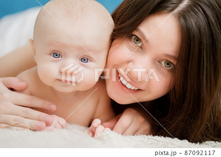 mom hugs the baby on the bed. close-up. maternal love and care.  87092117