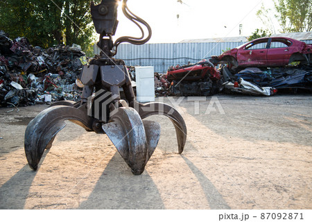 Large tracked excavator working a steel pile at a metal recycle yard. Industrial scrap metal recycling - selective focus, copy space 87092871
