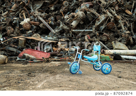 Large tracked excavator working a steel pile at a metal recycle yard. Industrial scrap metal recycling - selective focus, copy space Large tracked excavator working a steel pile at a metal recycle yard. Industrial scrap metal recycling - selective focus, copy space 87092874