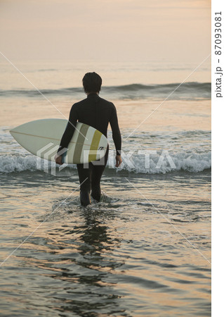 朝の海でサーフィンをする男性 87093081