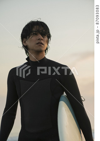 朝の海でサーフィンをする男性 87093083