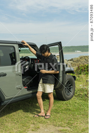 海辺でサングラスをかけた男性 87093486