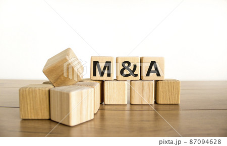 Mergers and acquisitions symbol. Concept words M and A - Mergers and acquisitions on wooden cubes on a beautiful white background. Business, mergers and acquisitions concept. Copy space. 87094628
