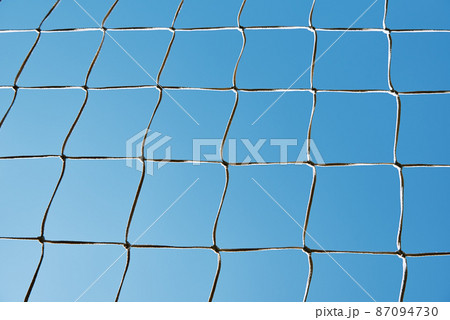 Soccer or football cage texture against blue sky 87094730
