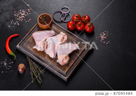 Chicken wings lie on a wooden board on a black background Chicken wings lie on a wooden board on a black background 87095484