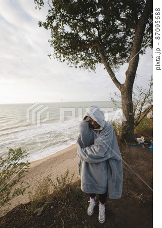Young woman on cold autumn seashore posing at camera Young woman on cold autumn seashore posing at camera 87095688
