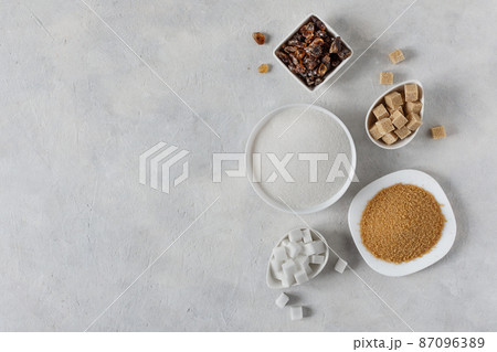 Different white and brown sugar in assortment top view on grey background. 87096389