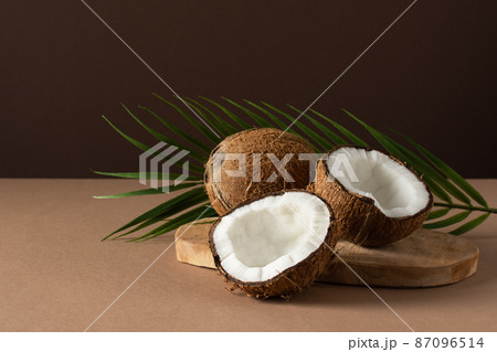 Coconuts with palm leaf over brown background. Coconuts with palm leaf over brown background. 87096514