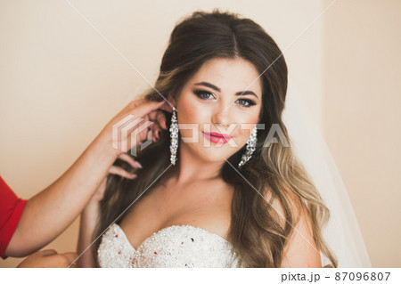 Gorgeous bride in robe posing and preparing for the wedding ceremony face in a room 87096807