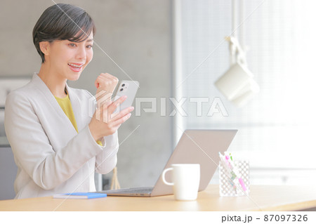 スマホを見てガッツポーズの女性1 スマホを見てガッツポーズの女性1 87097326