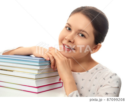 Smiling woman with a stack of books Smiling woman with a stack of books 87099208