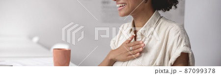 Smiling woman communicating in sign language online at a laptop Smiling woman communicating in sign language online at a laptop 87099378