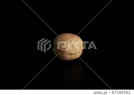 One inshell walnut on a black background 87100562