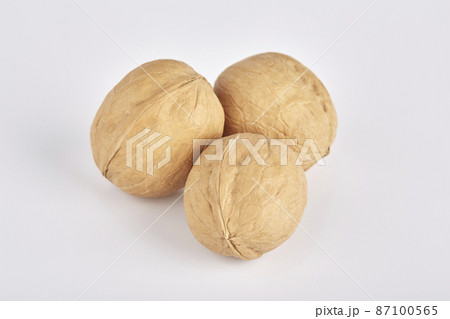 Three walnuts lie side by side on a white background 87100565