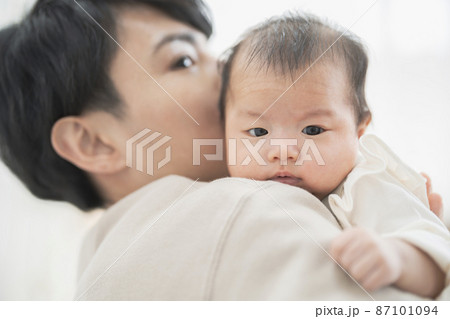 お父さんに抱っこされた生後2ヶ月の赤ちゃん 87101094