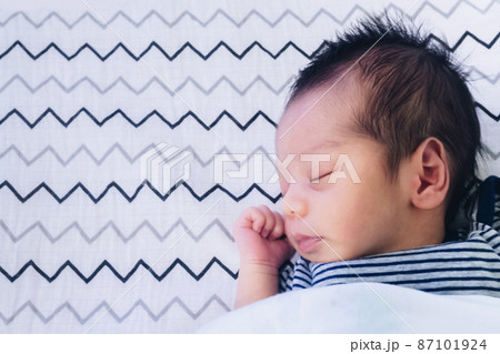 close up of cute little newborn asian baby boy sleeping on bed at children bedroom with copy space. family, healthy, life and relationship concept. close up of cute little newborn asian baby boy sleeping on bed at children bedroom with copy space. family, healthy, life and relationship concept. 87101924
