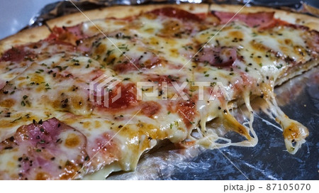 トマトベースのピザを半分に切る トマトベースのピザを半分に切る 87105070