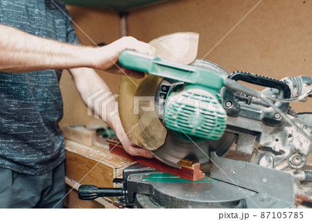 Framing Workshop. Sawing circular saw baguette handmade picture frame at studio. 87105785