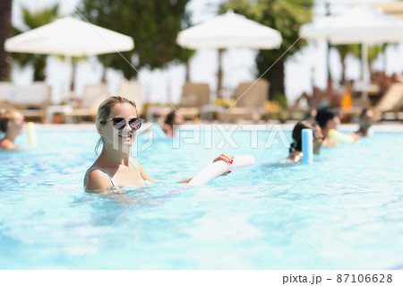 Beautiful woman with healthy body and vitality enjoys summer day in pool Beautiful woman with healthy body and vitality enjoys summer day in pool 87106628