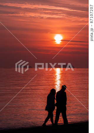 夕日とカップルのシルエット 87107207