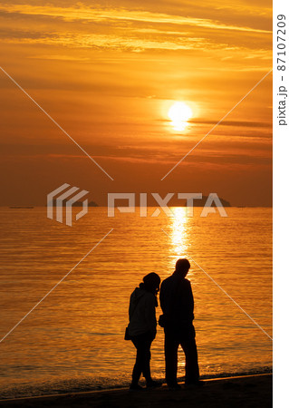 夕日とカップルのシルエット 87107209