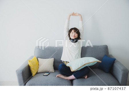 ソファで伸びをする女性 ソファで伸びをする女性 87107437