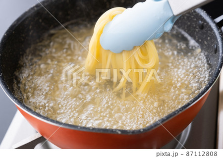 イタリアン料理のパスタ　フライパンから沸騰した水蒸気が湯気になって出ている 87112808