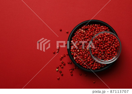 Black bowl of red peppercorns on red background Black bowl of red peppercorns on red background 87113707
