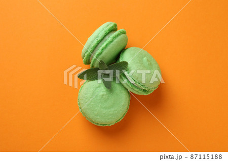 Concept of tasty dessert with macarons on orange background Concept of tasty dessert with macarons on orange background 87115188