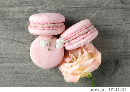 Concept of tasty dessert with macaroons on gray textured table Concept of tasty dessert with macaroons on gray textured table 87115192