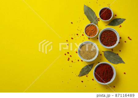 Different spices in white bowls on yellow background Different spices in white bowls on yellow background 87116489