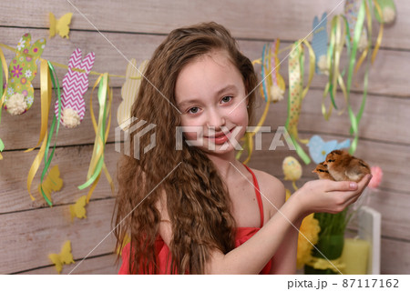 the girl is holding chickens in her hands. happy easter 87117162