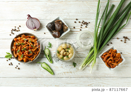 Concept of tasty food with marinated mushrooms on wooden table Concept of tasty food with marinated mushrooms on wooden table 87117667