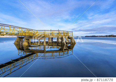 Yellow spilway with reflection on the water Yellow spilway with reflection on the water 87118770