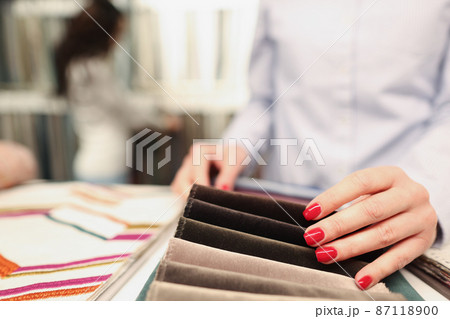 Woman chooses fabric in furniture store closeup 87118900