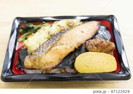 焼き鮭と竹輪磯辺揚げと玉子焼きと鶏の唐揚げが入った美味しい海苔弁当 87122029