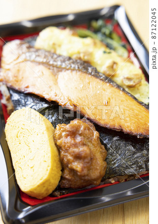 焼き鮭と竹輪磯辺揚げと玉子焼きと鶏の唐揚げが入った美味しい海苔弁当 87122045