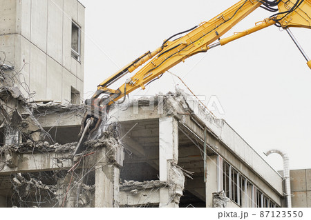 老朽化した公共建造物の解体作業をする重機 87123550
