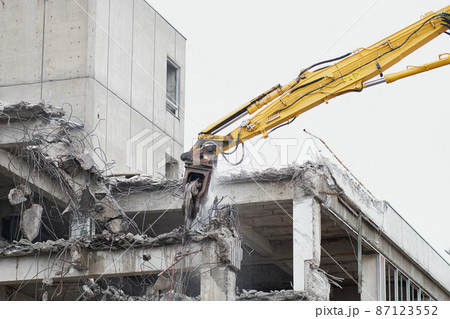 老朽化した公共建造物の解体作業をする重機 87123552