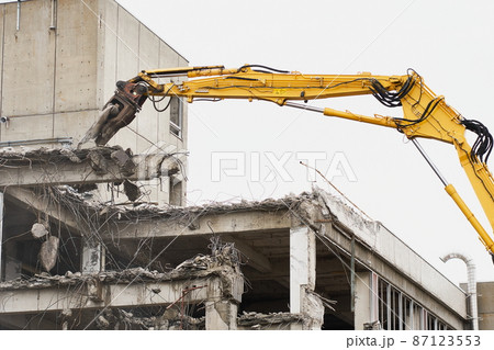 老朽化した公共建造物の解体作業をする重機 87123553