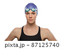 Swimmer female wearing swimming hat and goggles. Headshot portrait Swimmer female wearing swimming hat and goggles. Headshot portrait 87125740