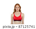 Red female athlete poses on a white background. Red female athlete poses on a white background. 87125741