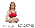 Red female athlete poses on a white background. Red female athlete poses on a white background. 87125742