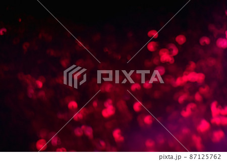 Neon bokeh light. Blur sparks. Festive glitz sparkles. Defocused red color glow shiny sequin pattern on dark black abstract background. Neon bokeh light. Blur sparks. Festive glitz sparkles. Defocused red color glow shiny sequin pattern on dark black abstract background. 87125762