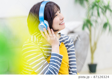 ヘッドフォンで音楽を聴く若い女性 ヘッドフォンで音楽を聴く若い女性 87126324
